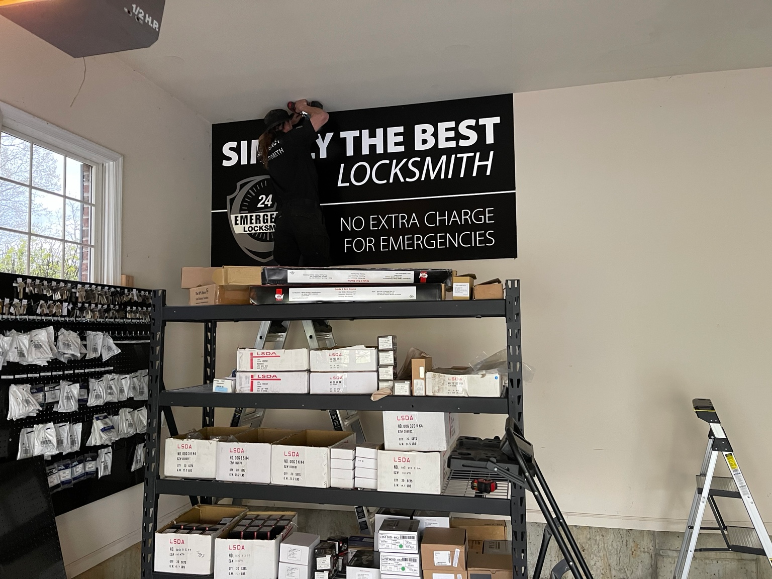 Locksmith workshop with keys, hardware, and a no extra charge for emergencies sign